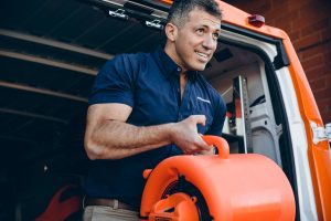 water damage restoration expert takes air mover out of van