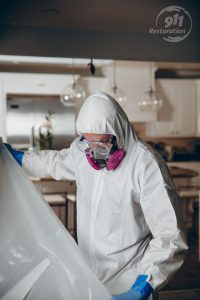 water damage restoration technicians taping off room in house