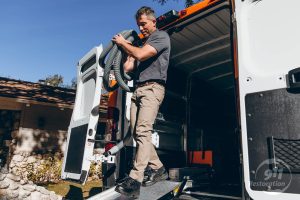 commercial water damage technician carries equipment out of vehicle