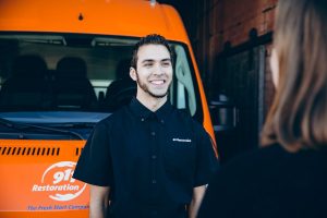 water damage restoration technician speaks with customer