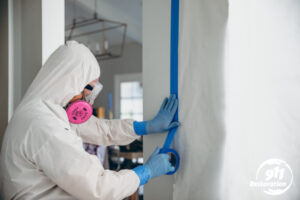 mold removal tech taping off wall